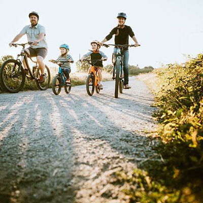 Man and woman on bikes flanking two small children on bikes 